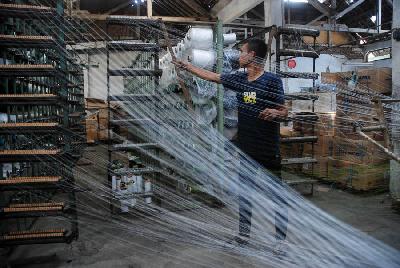 Pekerja mengatur alur benang di pabrik kain di Majalaya, Kabupaten Bandung, Jawa Barat.  TEMPO/Prima Mulia