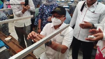Menteri Perdagangan Zulkifli Hasan mencoba membuat rokok tembakau di salah satu pabrik di Kudus, Jawa Tengah, usai bertemu dengan petani tembakau dan pelaku industri rokok, Rabu, 28 September 2022.