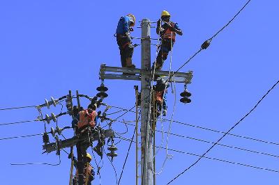 Sejumlah petugas PLN memindahkan jaringan kabel dari tiang listrik yang lama ke tiang yang baru di Kecamatan Alak, Kota Kupang, NTT, 2 Agustus 2022. ANTARA/Kornelis Kaha