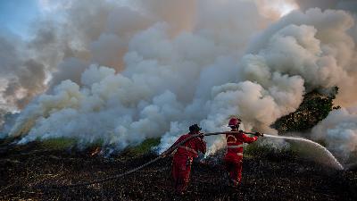 Officers of the Banyuasin firefighter attempt to extinguish a bushfire in Sukarame Village, Ogan Ilir, South Sumatra, in June.
ANTARA FOTO/Nova Wahyudi
