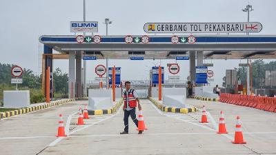 Petugas melintas di depan  gerbang Tol Pekanbaru-Dumai Seksi 1 di Kota Pekanbaru, Riau. ANTARA/FB Anggoro