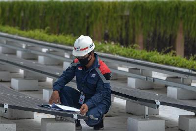 Petugas memeriksa instalasi panel surya di Jakarta. TEMPO/Tony Hartawan