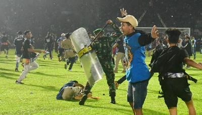Aparat menghalau suporter yang masuk ke lapangan usai pertandingan BRI Liga 1 antara Arema melawan Persebaya di Stadion Kanjuruhan, Malang, Jawa Timur, 1 Oktober 2022. REUTERS/Stringer 