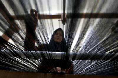 Perajin membuat kain tenun dengan menggunakan mesin tradisional di tempat produksi Usaha Mikro, Kecil dan Menengah (UMKM) Ija Kroeng, Banda Aceh, Aceh, 10 September 2022. ANTARA/Irwansyah Putra