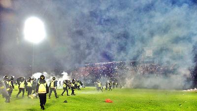 Police try to hold back fans from entering the field by firing tear gas at the end of the Arema FC-Persebaya match at the Kanjuruhan Stadium in Malang, East Java, October 1. Tempo/STR/Rizki Dwi Putra