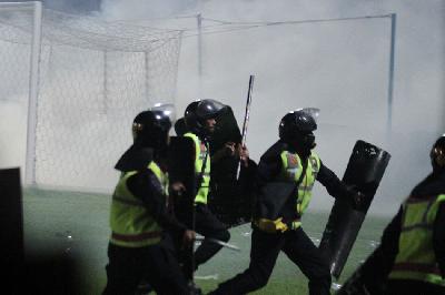 Polisi menghalau suporter yang masuk ke lapangan usai pertandingan BRI Liga 1 antara Arema melawan Persebaya di Stadion Kanjuruhan, Malang, Jawa Timur, 1 Oktober 2022. ANTARA/Ari Bowo Sucipto