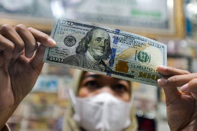Petugas valuta asing menghitung uang pecahan 100 dolar Amerika di Jakarta. TEMPO/Tony Hartawan