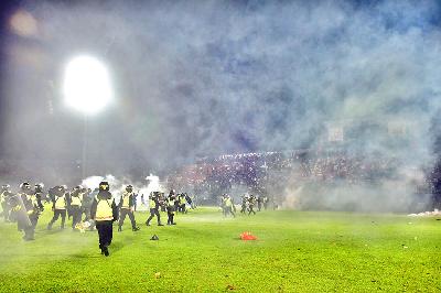 Polisi menghalau suporter usai pertandingan Arema FC melawan Persebaya Surabaya di Stadion Kanjuruhan, Malang, Jawa Timur, 1 Oktober 2022. TEMPO/Rizki Dwi Putra