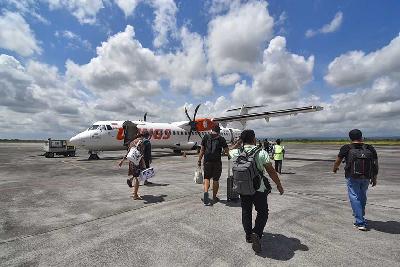 Sejumlah penumpang berjalan menuju pesawat tujuan Bali di Bandara Internasional Lombok, Praya, Lombok Tengah, NTB, 16 Oktober 2022. ANTARA/Ahmad Subaidi