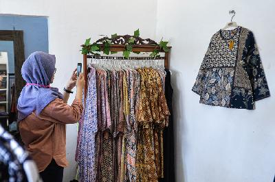 Pedagang memotret baju batik untuk dijual secara daring di Cipadu, Kota Tangerang, Banten. TEMPO/Tony Hartawan
