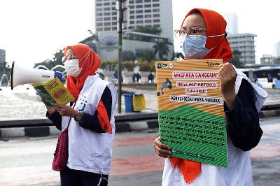 Petugas kesehatan Suku Dinas Kesehatan Jakarta Pusat membawa poster sosialisasi ginjal akut di Bundaran HI, Jakarta, 23 Oktober 2022. TEMPO/M Taufan Rengganis