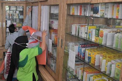 Pedagang menutup dengan kain lemari yang menyimpan obat sirup di apotek di Bekasi, Jawa Barat, 24 Oktober 2022. ANTARA/Fakhri Hermansyah