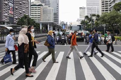 Pekerja melintas disaat sepulang kerja di Jalan Jenderal Sudirman, Jakarta, 26 Januari 2022. Dokumentasi TEMPO/Muhammad Hidayat