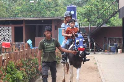 Pengunjung menunggangi kuda ditemani penjaga di Elite Stable, Serang, Banten, 1 November 2022. Tempo/Magang/Vhina Noviyanti