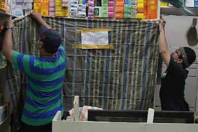 Pedagang menutup lemari penyimpan obat sirup usai inspeksi mendadak di apotek di Bekasi, Jawa Barat, 24 Oktober 2022. ANTARA/ Fakhri Hermansyah