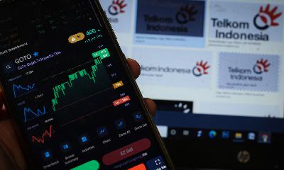 Investor memantau pergerakan saham GOTO melalui aplikasi telepon seluler di Jakarta. TEMPO/Hilman Fathurrahman W