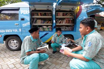 Pelajar membaca buku dari mobil perpustakaan keliling Dinas Perpustakaan dan Kearsipan (DPK) Aceh di Aceh Besar, Aceh, 26 Oktober 2022. ANTARA/Irwansyah Putra