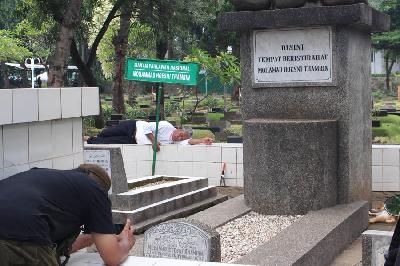 Salah satu anggota Indonesia Graveyard Atman memotret makam pahlawan MH Thamrin di TPU Karet Bivak, Jakarta, 5 November 2022. TEMPO/Magang/Vhina Noviyanti 