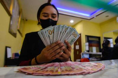 Petugas valuta asing menghitung uang pecahan 100 dolar Amerika di penukaran uang Dolarindo, Jakarta, 27 Juli 2022. Tempo/Tony Hartawan