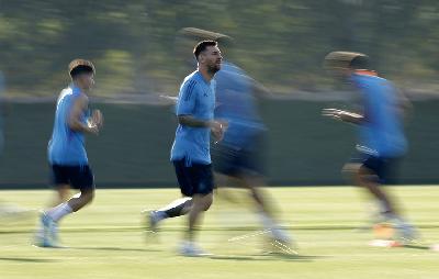 Penyerang tim nasional Argentina, Lionel Messi melakukan pemanasan pada sesi latihan di Qatar University Training Site 3, Doha, Qatar, 21 November 2022. REUTERS/Albert Gea