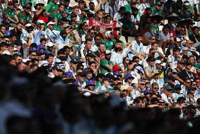 Sejumlah penonton pertandingan antara Argentina melawan Arab Saudi menggunakan topi dan menghalagi wajahnya dari cahaya matahari di Stadion Lusail, Lusail, Qatar, 22 November 2022. REUTERS/Carl Recine