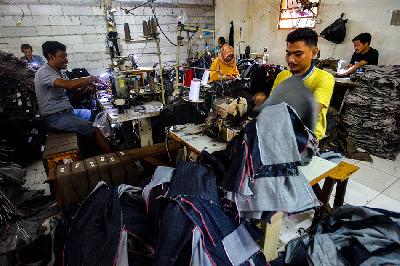 Pekerja menyelesaikan pembuatan celana jins di kawasan Pusat Industri Kecil Pulogadung, Jakarta, 21 November 2022. TEMPO/Tony Hartawan