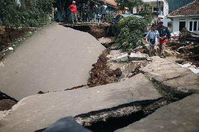 Warga melintas di jalanan yang rusak akibat gempa di Desa Sarampad, Kabupaten Cianjur, Jawa Barat, 22 November 2022. TEMPO/ Hilman Fathurrahman W