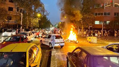 Motor polisi terbakar selama protes atas kematian Mahsa Amini,  di Teheran, Iran, 19 September 2022. WANA via REUTERS/File Foto