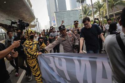 Petugas kepolisian membubarkan aktivis yang membentangkan spanduk saat aksi jalan pagi bersama tolak RKUHP pada Hari Bebas Kendaraan Bermotor di Bundaran HI, Jakarta, 27 Noveber 2022. TEMPO/M Taufan Rengganis
