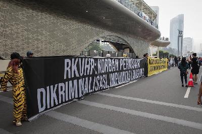 Aktivis membentangkan spanduk menolak pengesahan Rancangan Kitab Undang-Undang Hukum Pidana (RKUHP) pada Hari Bebas Kendaraan Bermotor  di Bundaran HI, Jakarta, 27 November 2022. TEMPO/M Taufan Rengganis