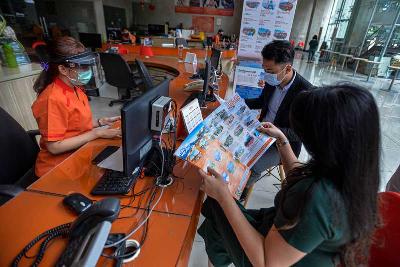 Petugas biro perjalanan melayani pelanggan di Jakarta. Tempo/Tony Hartawan