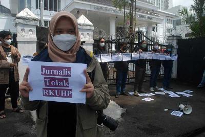Seorang jurnalis memegang  poster protes di depan gedung DPRD Jawa Barat di Bandung, 5 Desember 2022. TEMPO/Prima mulia
