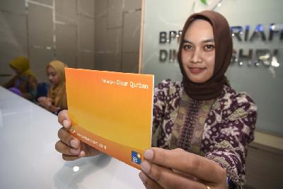 Karyawan Bank Perkreditan Rakyat Syariah (BPRS) Dinar Ashri menunjukkan buku produk tabungan syariah Dinar Qurban di Mataram, NTB, 2019.  ANTARA
