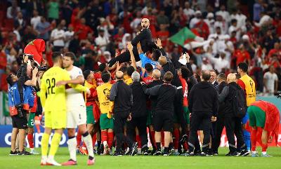 Pelatih Maroko Walid Reragui dengan para pemain setelah mengalahkan Portugal pada pertandingan Perempat Final di Stadion Al Thumama, Doha, Qatar, 10 Desember 2022. REUTERS/Bernadett Szabo