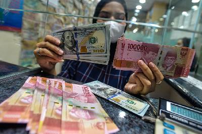 Petugas merapikan uang dolar Amerika dan uang Rupiah di tempat penukaran Valuta Asing di  Kuningan, Jakarta. TEMPO/Tony Hartawan
