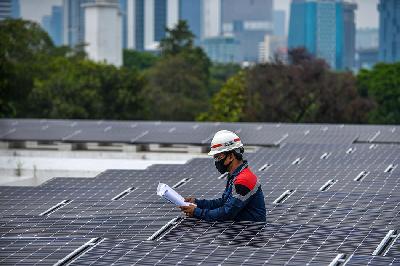 Petugas memeriksa instalasi panel surya di Jakarta. TEMPO/Tony Hartawan