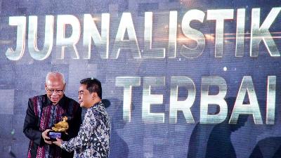 Mantan Ketua Dewan Pers Bagir Manan (kiri) memberikan piala penghargaan kepada wartawan Tempo Agung Sedayu saat Anugerah Dewan Pers di Bandung, Jawa Barat, 13 Desember 2022. ANTARA/Raisan Al Farisi