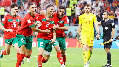 Achraf Hakimi bersama pemain Maroko merayakan kemenangan timnya, usai berhasil mengalahkan Spanyol dalam adu penalti, di Stadion Education City, Al Rayyan, Qatar,  6 Desember 2022/REUTERS/Matthew Childs