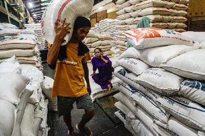 Pekerja melintas dekat tumpukan beras impor dari Vietnam di Pasar Induk Beras Cipinang, Jakarta, 7 November 2022. TEMPO/Tony Hartawan