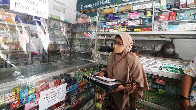 An official of the Food and Drug Monitoring Agency (BPOM) inspects a pharmacy over the sale of syrup medicines in Kediri, East Java, November 15.
Antara/Prasetia Fauzani
