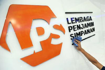Karyawan membersihkan logo baru Lembaga Penjamin Simpanan (LPS) di Jakarta, 2019. ANTARA/Audy Alwi
