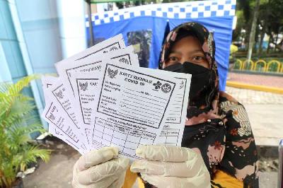 Petugas kesehatan memperlihatkan kartu vaksinasi COVID-19 di rest area mudik Natal dan Tahun Baru di Kota Kediri, Jawa Timur, 23 Desember 2022. ANTARA/Prasetia Fauzani