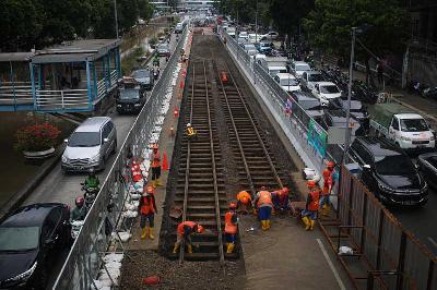 Pekerja membongkar aspal yang menutup jalur trem masa kolonial Belanda di lokasi proyek pembangunan MRT Jakarta fase 2 di kawasan Gajah Mada, Jakarta, 9 November 2022. Tempo/Hilman Fathurrahman W