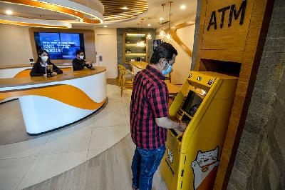 Nasabah menggunakan mesin anjungan tunai mandiri (ATM) di digital lounge Bank Neo Commerce, Jakarta, 26 Oktober 2021. TEMPO/Tony Hartawan
