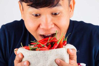 Ilustrasi seorang pria akan memakan cabai. Shutterstock