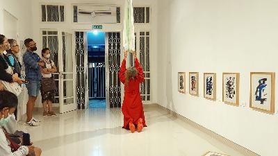 Performance penari Fitri Setyaningsih (bergaun merah) di tengah pameran tunggal lukisan abstrak karya perupa Ferdy Thaeras bertema "Les Bonnes" di Galeri IFI, LIP Yogyakarta, 23 Desember 2022. TEMPO/Pito Agustin Rudiana