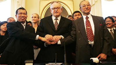 Justice Minister Hamid Awaluddin (left) shakes hands with the Free Aceh Movement's (GAM) Chair Malik Mahmood (right) in the presence of Finland's former president Martti Ahtisaari (center) after the signing of a peace agreement in Helsinki, August 15, 2005. The truce aimed to end three decades of fighting in Aceh. 
REUTERS/Ruben Sprich/File Photo
