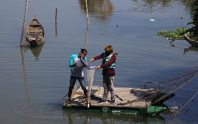 Anggota tim peneliti dari Ecological Observation and Wetlands Conservation (Ecoton) menyaring air untuk meneliti kandungan mikroplastik di sungai kawasan Karang Pilang, Surabaya, Jawa Timur, 4 Juli 2020. ANTARA/Moch Asim