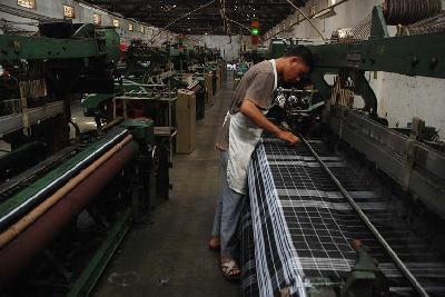 Operator mesin di sebuah pabrik kain skala kecil menengah di Desa Rancajigang, Kecamatan Majalaya, Kabupaten Bandung, Jawa Barat. TEMPO/Prima Mulia