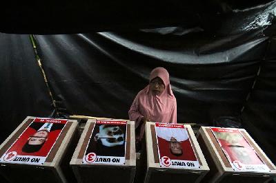 Warga mengamati gambar calon pada kota suara saat akan menggunakan hak pilihnya pada Pemilihan Kepala Desa (Pilkades) Serentak di Lhokseumawe, Aceh, Minggu 18 Desember 2022.  ANTARA/Rahmad